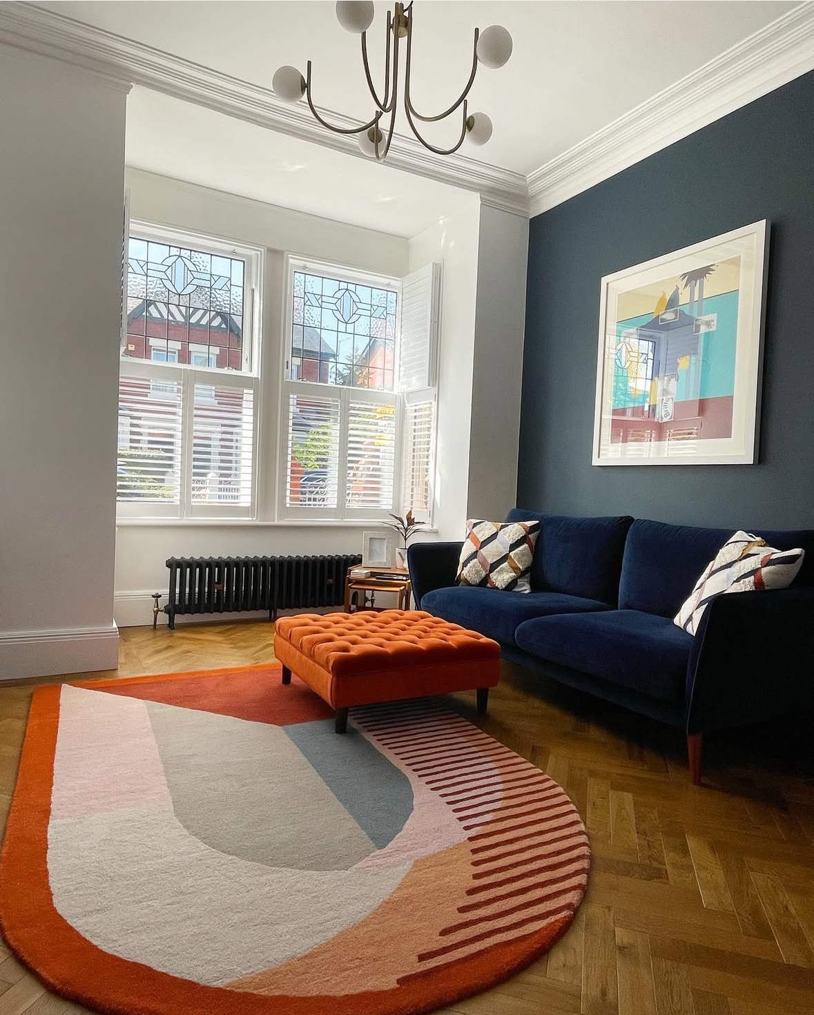 Modern living room with stylish decor and bay window cast iron radiators.