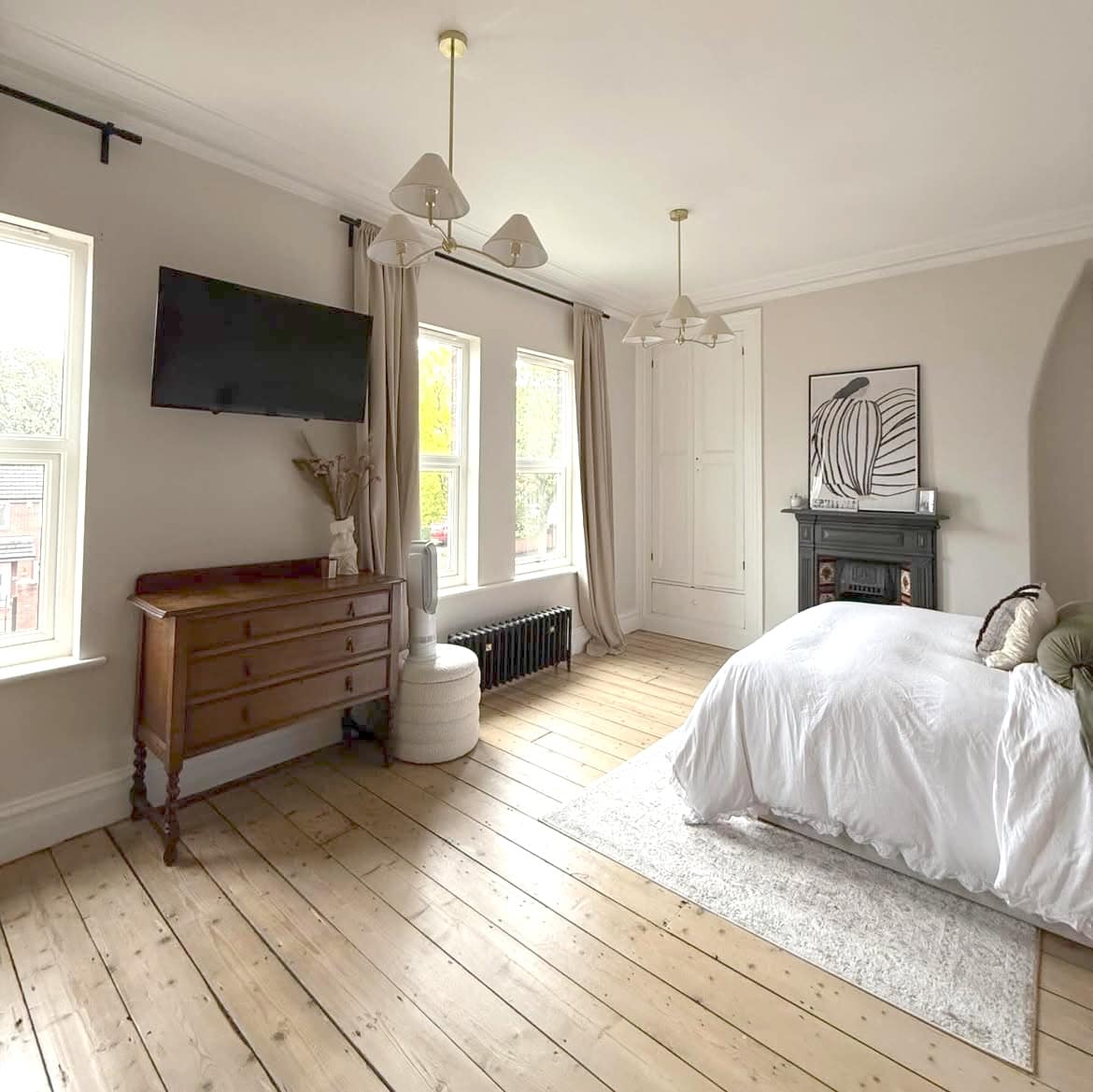 Bright, spacious, modern bedroom interior with cast iron radiator.